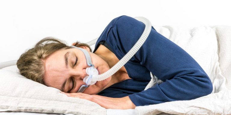 terapia CPAP. femeie care doarme pe lateral si foloseste terapiea CPAP pentru tratarea apneei in somn | neuroaxis