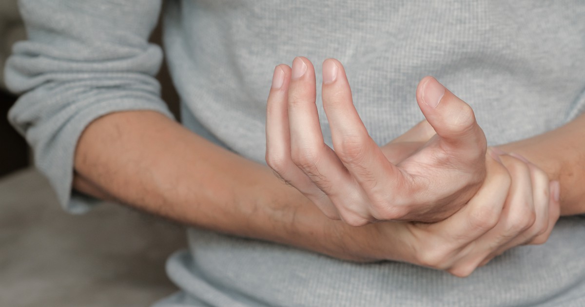 barbat care se confrunta cu maini amortite din cauza lipsei de magneziu